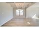 Elegant dining room with hardwood floors, coffered ceilings, and a stylish chandelier fixture at 107 St Annes Pl, Covington, GA 30016