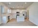 A bright kitchen with white cabinets, stainless steel appliances, and a center island with pendant lights at 107 St Annes Pl, Covington, GA 30016
