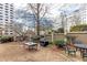 Spacious backyard with multiple seating areas, lush greenery, and a covered grill at 2499 Peachtree Ne Rd # 108, Atlanta, GA 30305