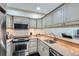 Galley kitchen featuring stainless steel appliances, light wood cabinetry, and granite countertops at 2499 Peachtree Ne Rd # 108, Atlanta, GA 30305