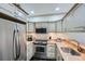 Galley kitchen featuring stainless steel appliances, granite countertops, and light wood cabinetry at 2499 Peachtree Ne Rd # 108, Atlanta, GA 30305