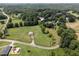 Aerial view of a charming countryside home with a barn, lush green fields, and mature trees at 255 Henson Way, Canton, GA 30115