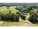 Aerial view of a home featuring dark roof, green lawns, and mature trees at 255 Henson Way, Canton, GA 30115