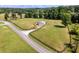 An aerial view of a fenced-in barn, set amongst lush green fields and mature trees at 255 Henson Way, Canton, GA 30115