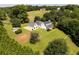 Aerial view of a white home, featuring a covered porch, expansive lawns, and mature trees at 255 Henson Way, Canton, GA 30115