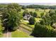Aerial view of a white home featuring a dark roof, surrounded by green lawns and mature trees at 255 Henson Way, Canton, GA 30115