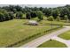 Aerial view of a fenced barn amidst lush greenery and mature trees, accessible from a nearby road at 255 Henson Way, Canton, GA 30115