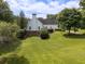 Expansive backyard featuring lush green lawn, mature trees, and a white home with a brick foundation at 255 Henson Way, Canton, GA 30115