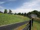 Charming view of a barn surrounded by lush pastureland and a classic black fence at 255 Henson Way, Canton, GA 30115