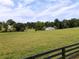 Picturesque view of barn on a farm surrounded by lush fields and mature trees at 255 Henson Way, Canton, GA 30115