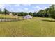 Aerial view of a white barn in a fenced pasture surrounded by green grass and trees at 255 Henson Way, Canton, GA 30115