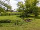 Tranquil scene featuring a barn, fenced pasture, trees, and a gently flowing stream at 255 Henson Way, Canton, GA 30115