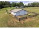 A fenced barn features a metal roof surrounded by expansive green land at 255 Henson Way, Canton, GA 30115