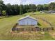 Fenced barn with a metal roof and large access doors surrounded by expansive green land at 255 Henson Way, Canton, GA 30115