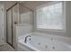 Large soaking tub and separate shower with glass enclosure in a bright bathroom at 255 Henson Way, Canton, GA 30115