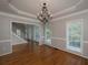 Elegant dining room featuring staircase view, decorative chandelier, and hardwood floors at 255 Henson Way, Canton, GA 30115