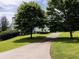 Long driveway leading to a well-maintained home, surrounded by mature trees and lush landscaping at 255 Henson Way, Canton, GA 30115