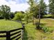 Idyllic landscape featuring a well-maintained fence, trees, and a meandering stream at 255 Henson Way, Canton, GA 30115