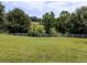 Scenic view of a well-manicured field bordered by a white fence and mature trees at 255 Henson Way, Canton, GA 30115