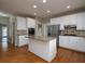 Modern kitchen features white cabinets, stainless appliances, granite countertops, and hardwood floors at 255 Henson Way, Canton, GA 30115