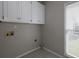 Functional laundry room with overhead cabinets, window and convenient utility hookups at 255 Henson Way, Canton, GA 30115