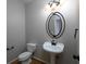 Elegant powder room featuring a pedestal sink, decorative mirror and modern fixtures at 255 Henson Way, Canton, GA 30115