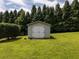 Well maintained shed with double doors and surrounded by green grass and tall trees at 255 Henson Way, Canton, GA 30115