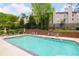 Community pool surrounded by lounge chairs, lush landscaping, and apartment buildings at 1140 Moorestown Cir, Decatur, GA 30033