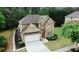 An aerial view showcasing the home's landscaping, large driveway and treed perimeter at 1990 Cooper Lakes Dr, Grayson, GA 30017