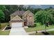 Charming two-story home with a brick facade, attached garage, manicured lawn, and mature trees at 1990 Cooper Lakes Dr, Grayson, GA 30017