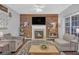 Cozy living room with fireplace, wood accent wall, and views of the front yard at 1990 Cooper Lakes Dr, Grayson, GA 30017
