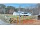 Fenced backyard with fire pit and dog kennel, adjacent to a white one-story home at 2885 Green Rd, Loganville, GA 30052