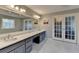 Bright bathroom featuring double sinks, large mirror and french doors at 2885 Green Rd, Loganville, GA 30052