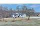 Wide shot of a two-story home with an attached garage and large front yard surrounded by mature trees at 2885 Green Rd, Loganville, GA 30052