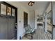 Inviting front porch with a cozy bench, stylish light fixtures, and a charming black front door at 2885 Green Rd, Loganville, GA 30052