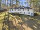 Back view of white brick home with deck overlooking backyard and tall trees at 4178 Castle Pines Ct, Tucker, GA 30084