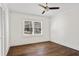 Bright bedroom features white walls, a ceiling fan, and a window overlooking the backyard at 4178 Castle Pines Ct, Tucker, GA 30084