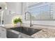 Close-up of the kitchen sink with granite countertops, a white tile backsplash, and a stainless steel faucet at 4178 Castle Pines Ct, Tucker, GA 30084