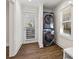 Clean laundry room with modern stackable washer and dryer, a window, and wood floors at 4178 Castle Pines Ct, Tucker, GA 30084