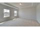 Bright and spacious carpeted main bedroom with tray ceiling and two windows offering natural light at 612 Sidney Ct, Stockbridge, GA 30281