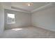 Bright and spacious carpeted main bedroom with tray ceiling and a large window offering natural light at 612 Sidney Ct, Stockbridge, GA 30281