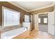 Serene bathroom with a soaking tub, separate shower, and decorative window, connecting to the Primary bedroom at 737 Heritage Post Ln, Grayson, GA 30017