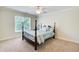 Bedroom with four-poster bed, neutral carpet, ceiling fan, and a sunny window at 737 Heritage Post Ln, Grayson, GA 30017