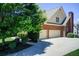 Side view of brick home showcasing a three-car garage and long driveway at 737 Heritage Post Ln, Grayson, GA 30017