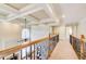 Upstairs hallway overlooking a fireplace, featuring hardwood railings and coffered ceilings at 737 Heritage Post Ln, Grayson, GA 30017