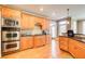 Spacious kitchen with stainless steel double oven, light wood cabinets, and granite countertops at 737 Heritage Post Ln, Grayson, GA 30017