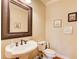 Elegant powder room featuring a pedestal sink, decorative mirror, and charming wall art at 737 Heritage Post Ln, Grayson, GA 30017