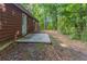 Property's exterior reveals brown siding, a concrete patio, and a verdant, treed backdrop at 340 Onyx Ct, Atlanta, GA 30349