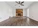 Bright living room featuring a stone fireplace, hardwood floors, and a modern ceiling fan at 3664 Nessa Se Ct, Smyrna, GA 30082