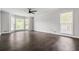 Spacious living room with hardwood flooring, ceiling fan, and natural light from large windows at 3664 Nessa Se Ct, Smyrna, GA 30082
